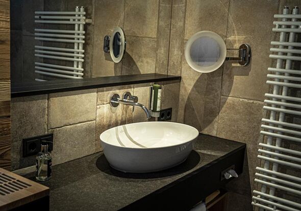 The newly renovated bathrooms at DAS Hintersee are dark and elegant.