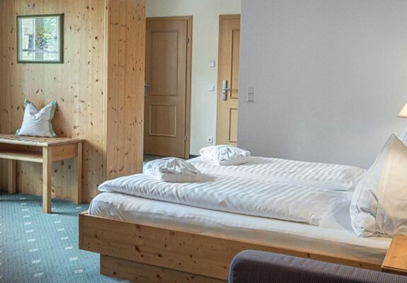 The double bed of the Sonnberg Double Room Classic, with a view of the newly panelled wooden wall