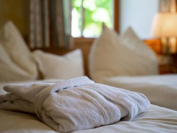 Ein Bademantel auf dem frisch gedeckten Doppelbett