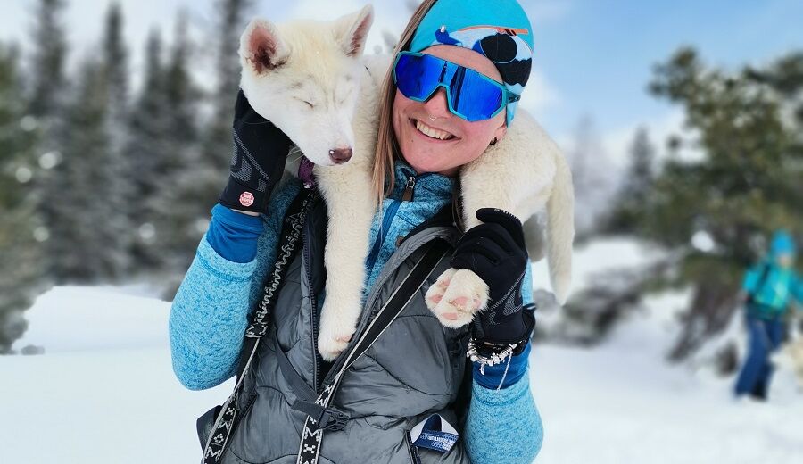 Eine Frau die einen Husky auf der Schulter hat.
