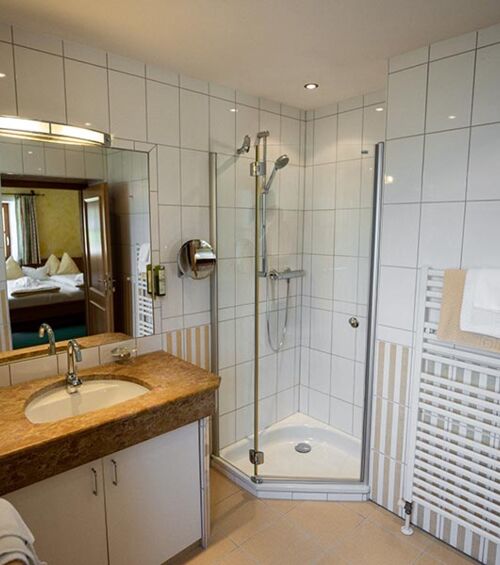 The white tiled bathroom with spacious shower