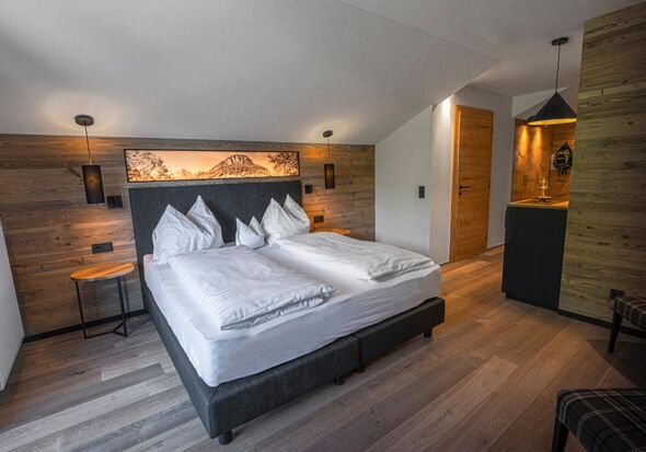 Double bed in a hotel room with many wooden elements