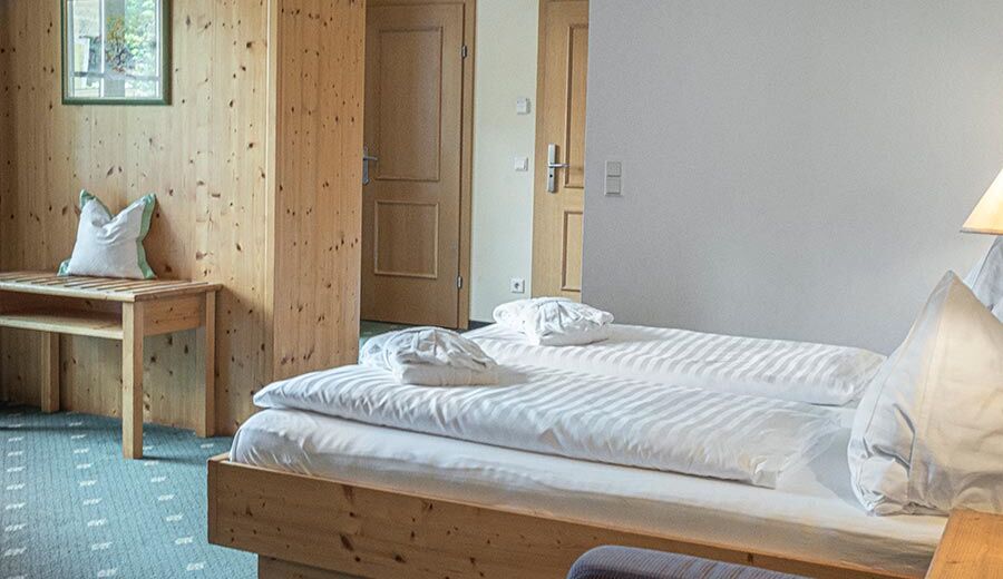 The double bed of the Sonnberg Double Room Classic, with a view of the newly panelled wooden wall