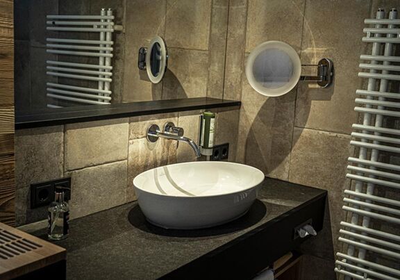 The newly renovated bathrooms at DAS Hintersee are dark and elegant.