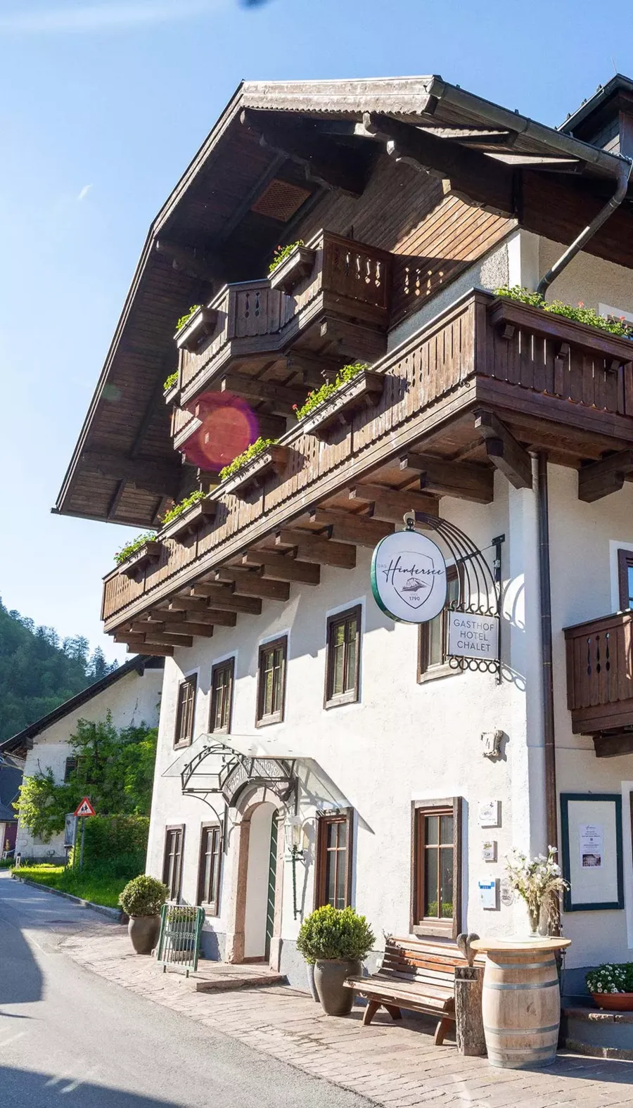 The traditional Austrian-style façade of the Hotel DAS Hintersee with balcony and guesthouse sign