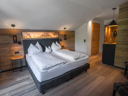 Double bed in a hotel room with many wooden elements