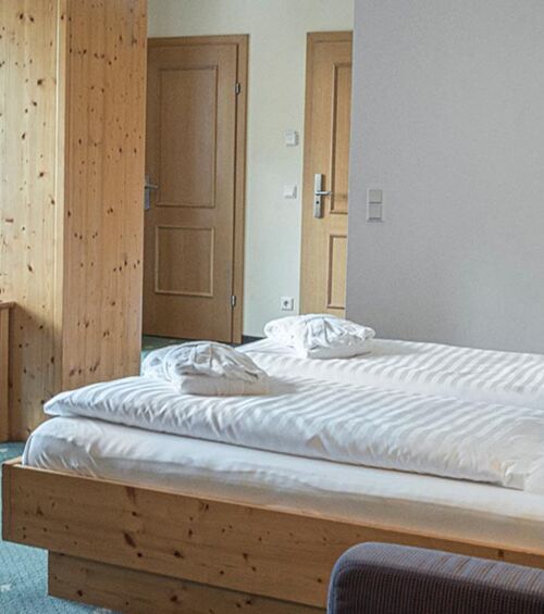 The double bed of the Sonnberg Double Room Classic, with a view of the newly panelled wooden wall