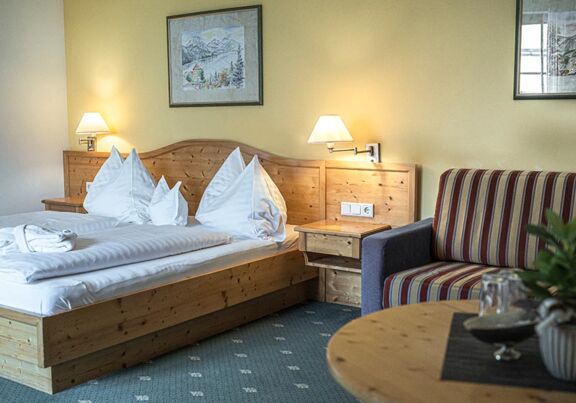 The modern wooden furnishings of the Sonnberg Double Room Classic with comfortable couch