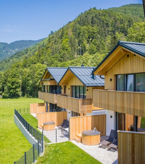 Blick vom Balkon eines Ferienhauses auf 3 weitere Luxus-Chalets im Salzkammergut