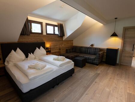 Double bed, couch and window dormer over a bed