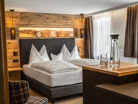 The cosy double bed with stylish wood panelling on the wall