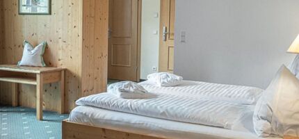 The double bed of the Sonnberg Double Room Classic, with a view of the newly panelled wooden wall