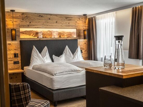 The cosy double bed with stylish wood panelling on the wall