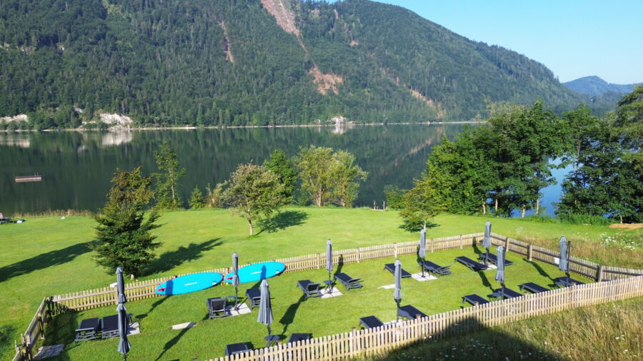 Hoteleigener Badeplatz am Hintersee mit Sonnenschirmen und Liegen
