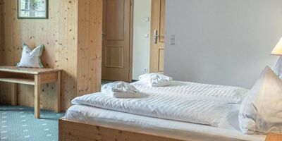 The double bed of the Sonnberg Double Room Classic, with a view of the newly panelled wooden wall