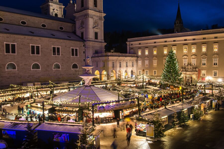 Am Residenzplatz in Salzburg sind verschiedene Stände des Christkindlmarktes aufgebaut mit weihnachtlichem Schmuck und Lichterketten. Die Atmosphäre am Abend ist sehr gemütlich. © Tourismus Salzburg GmbH – Günther Breitegger