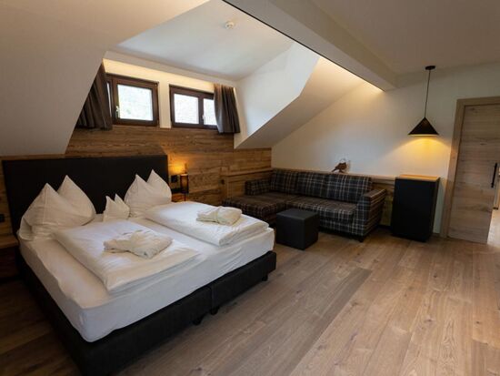 Double bed, couch and window dormer over a bed