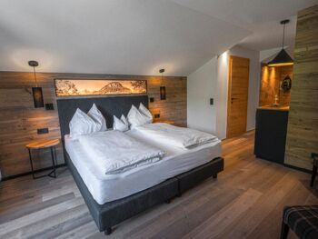 Double bed in a hotel room with many wooden elements