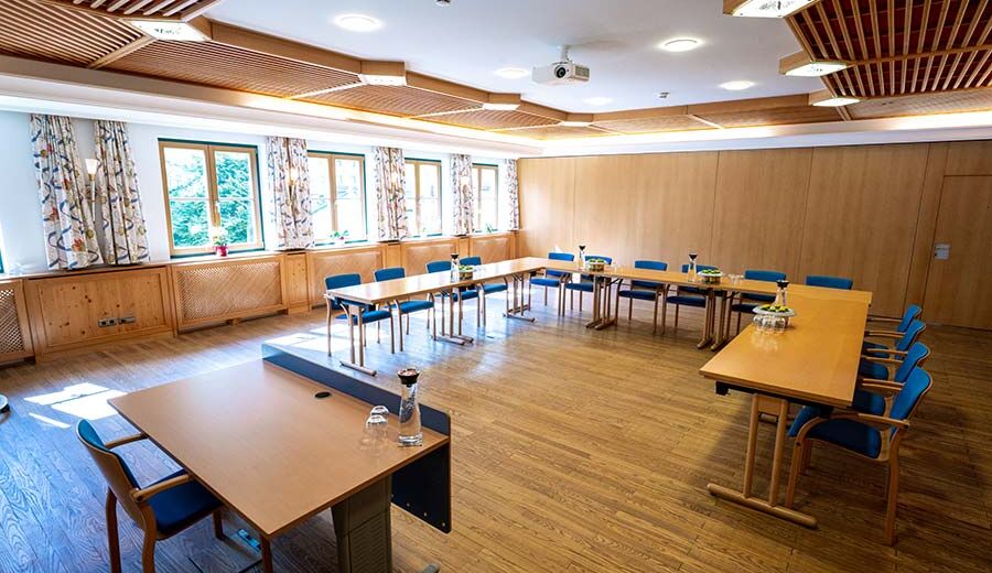 A conference room with a speaker's lectern and the remaining tables and chairs arranged in a U formation