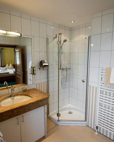 The white tiled bathroom with spacious shower