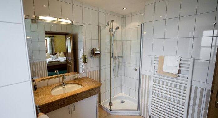 The white tiled bathroom with spacious shower