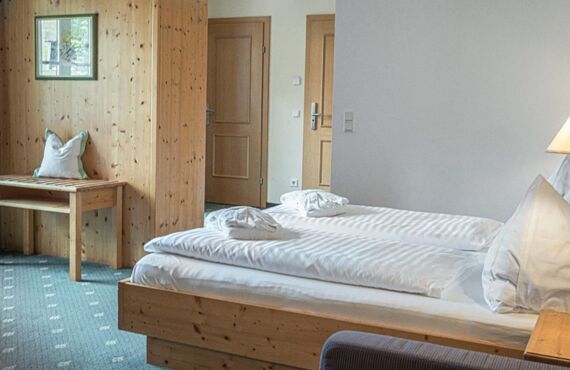 The double bed of the Sonnberg Double Room Classic, with a view of the newly panelled wooden wall