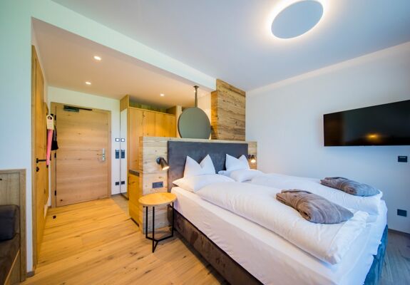 Entrance area and double bed in the chalet at Das Hintersee in Salzkammergut in Austria