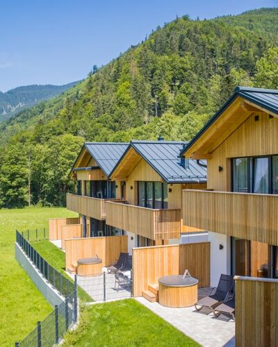 Blick vom Balkon eines Ferienhauses auf 3 weitere Luxus-Chalets im Salzkammergut