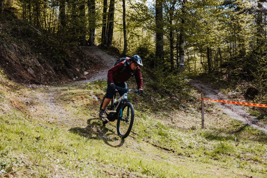 Ein Biker fährt mit seinem E-Mountainbike durch das Mountainbike-Übungsgelände des Hotel DAS Hintersee.