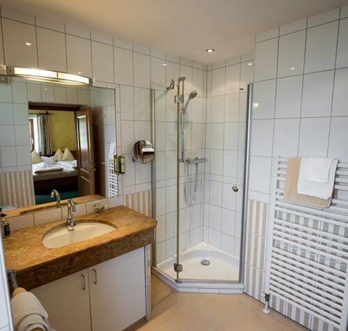 The white tiled bathroom with spacious shower