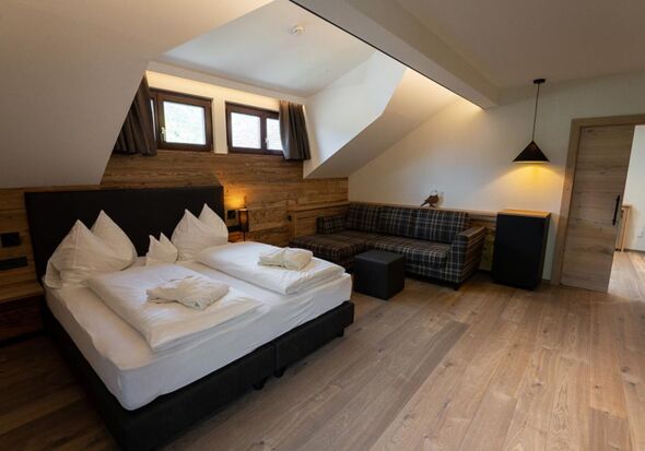 Double bed, couch and window dormer over a bed