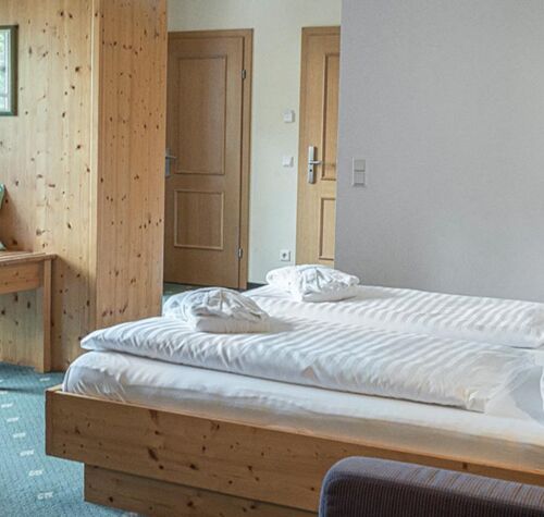 The double bed of the Sonnberg Double Room Classic, with a view of the newly panelled wooden wall